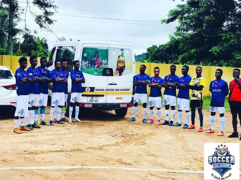Players in blue kit standing beside the academy's branded minibus