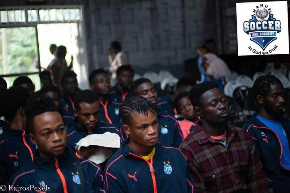 Players in navy academy tracksuits seated together indoors